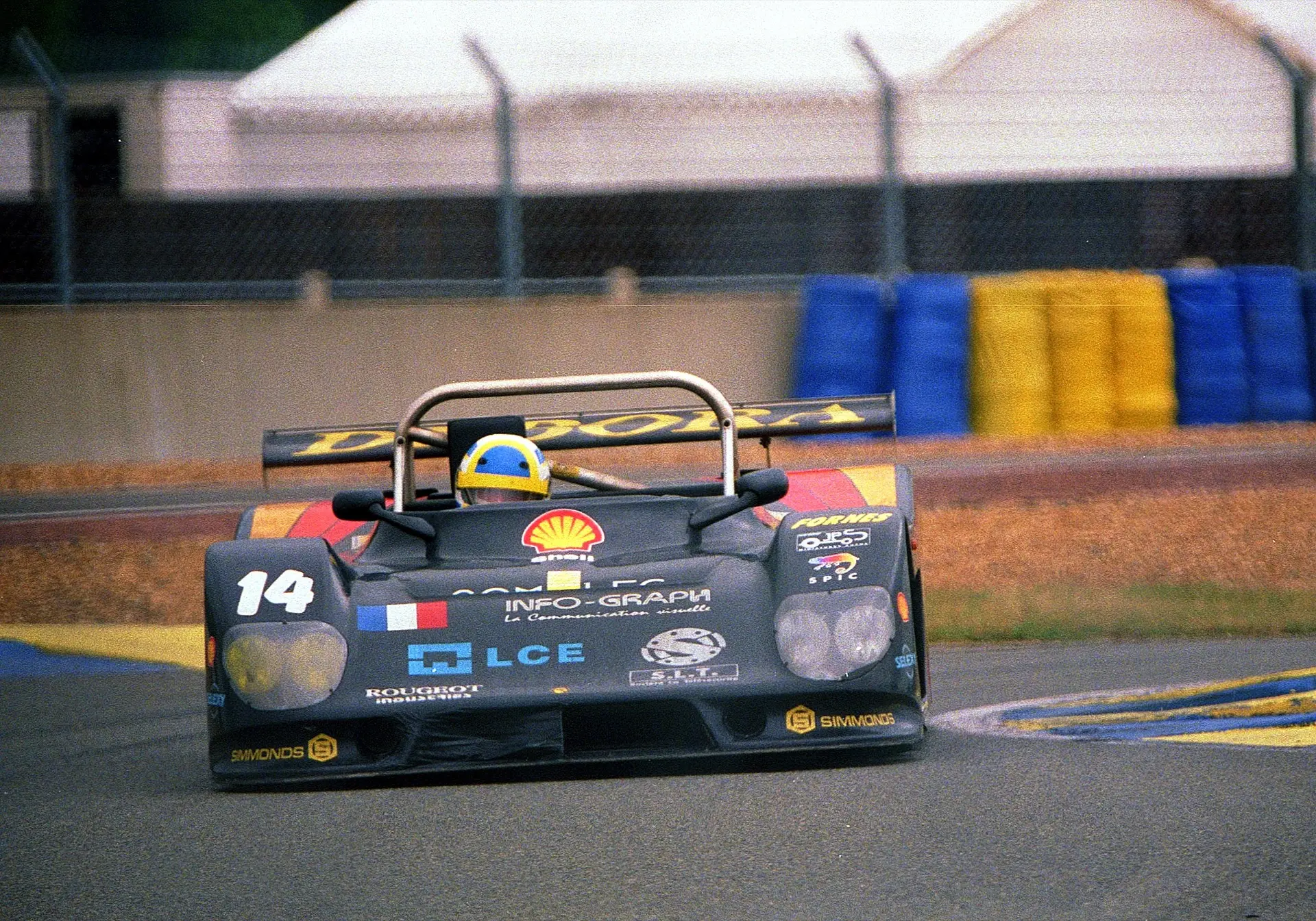 A dark privateer Le Mans prototype, car 14, on track at the 1995 24 Hours of Le Mans with sand traps behind it.
