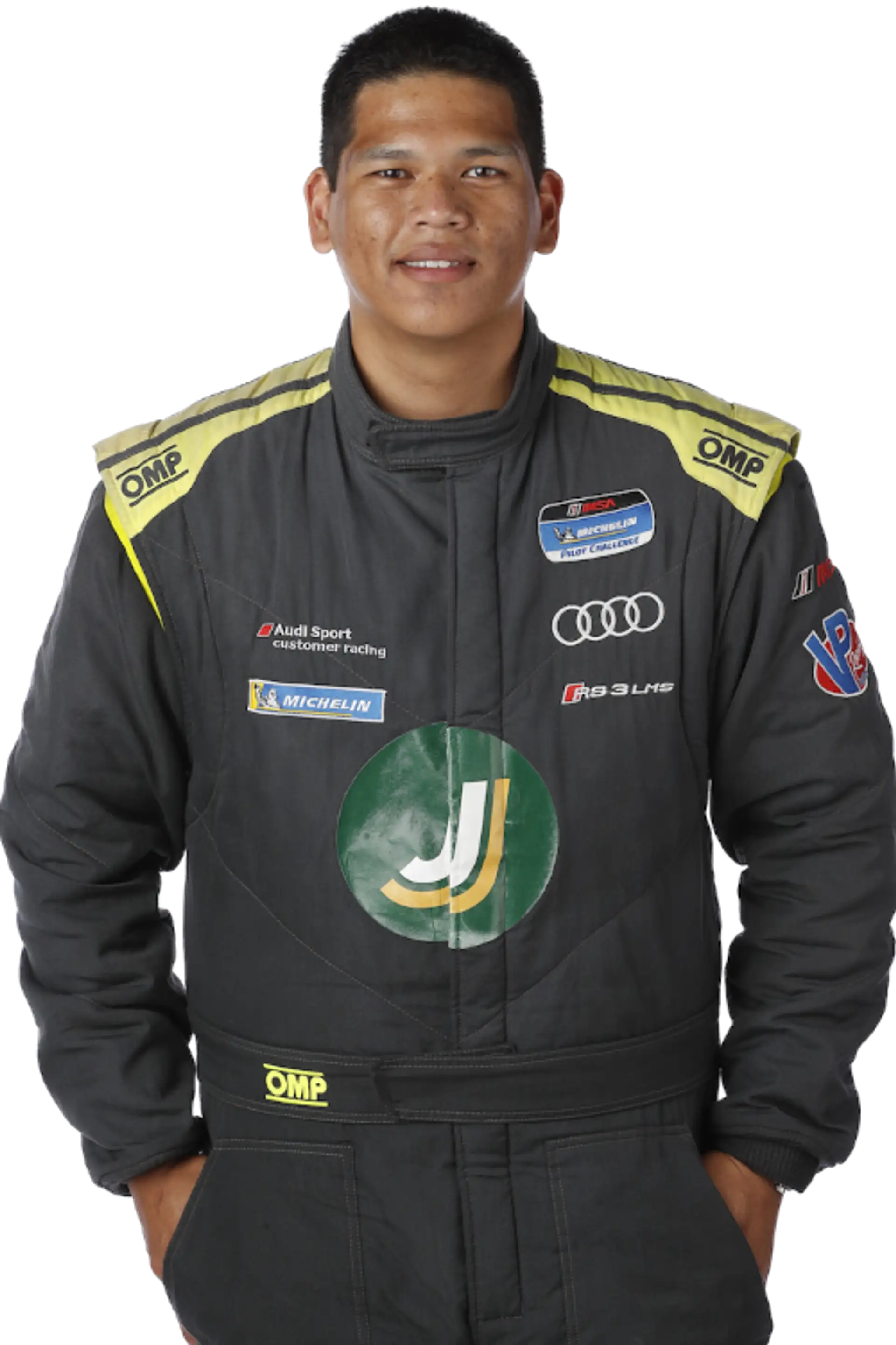 A studio headshot of Gino Manley in a black and yellow race suit, arms behind his back, a slight smile.