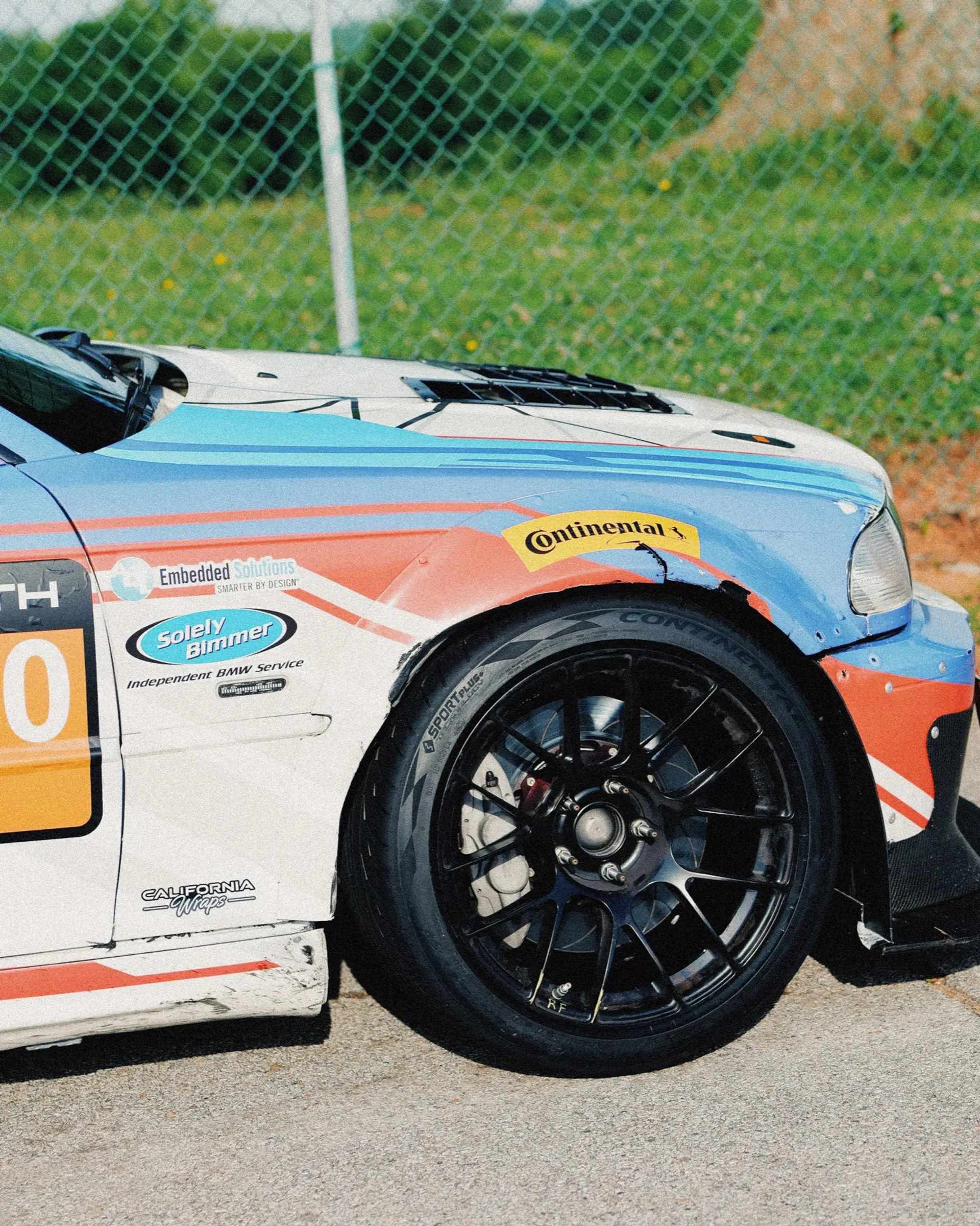 The front of a GT car at VIR, Continental tires and brake ducts in shallow focus.