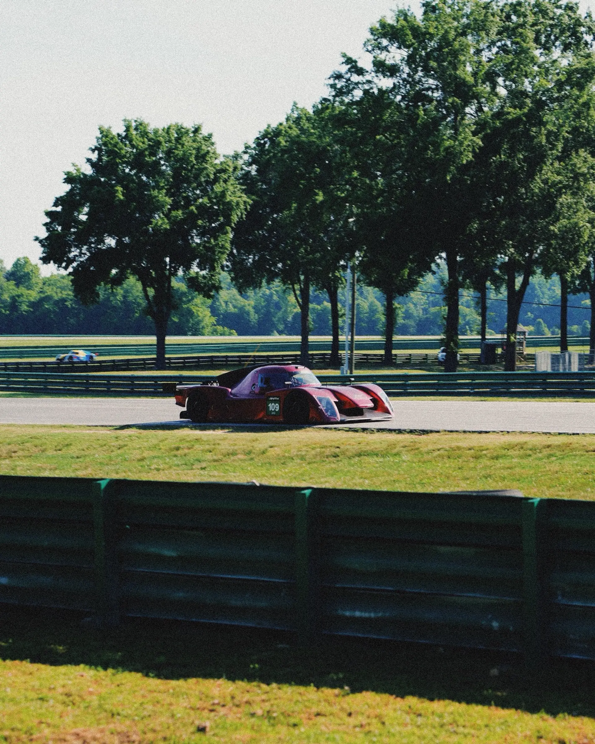 A prototype committed through a fast, tree-lined corner at VIR.